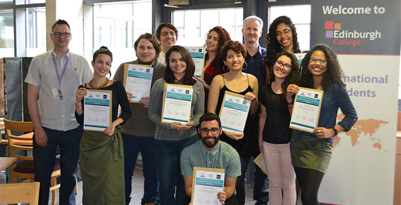 Group of international students from Brazil holding up certificates and smiling at camera. 